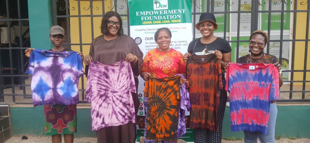 Participants smiling and displaying colourful tie-dye shirts completed during training